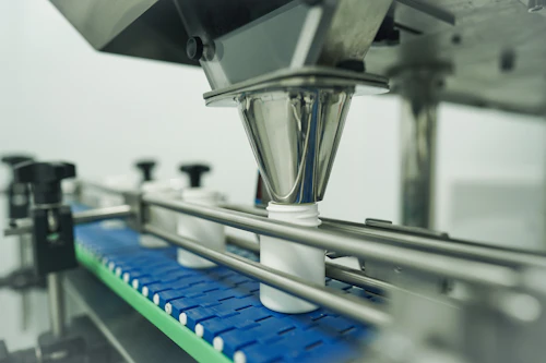 Filling heads dosing product into containers on a packaging line