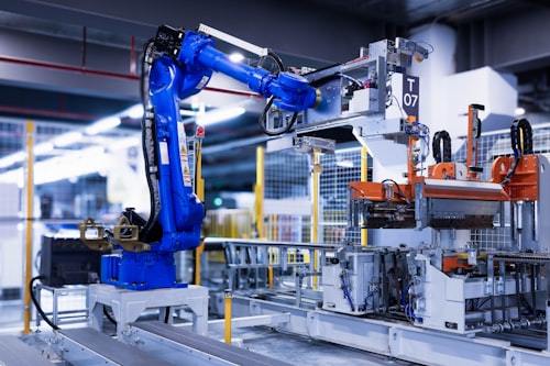 Industrial robot arm working inside a guarded automation cell
